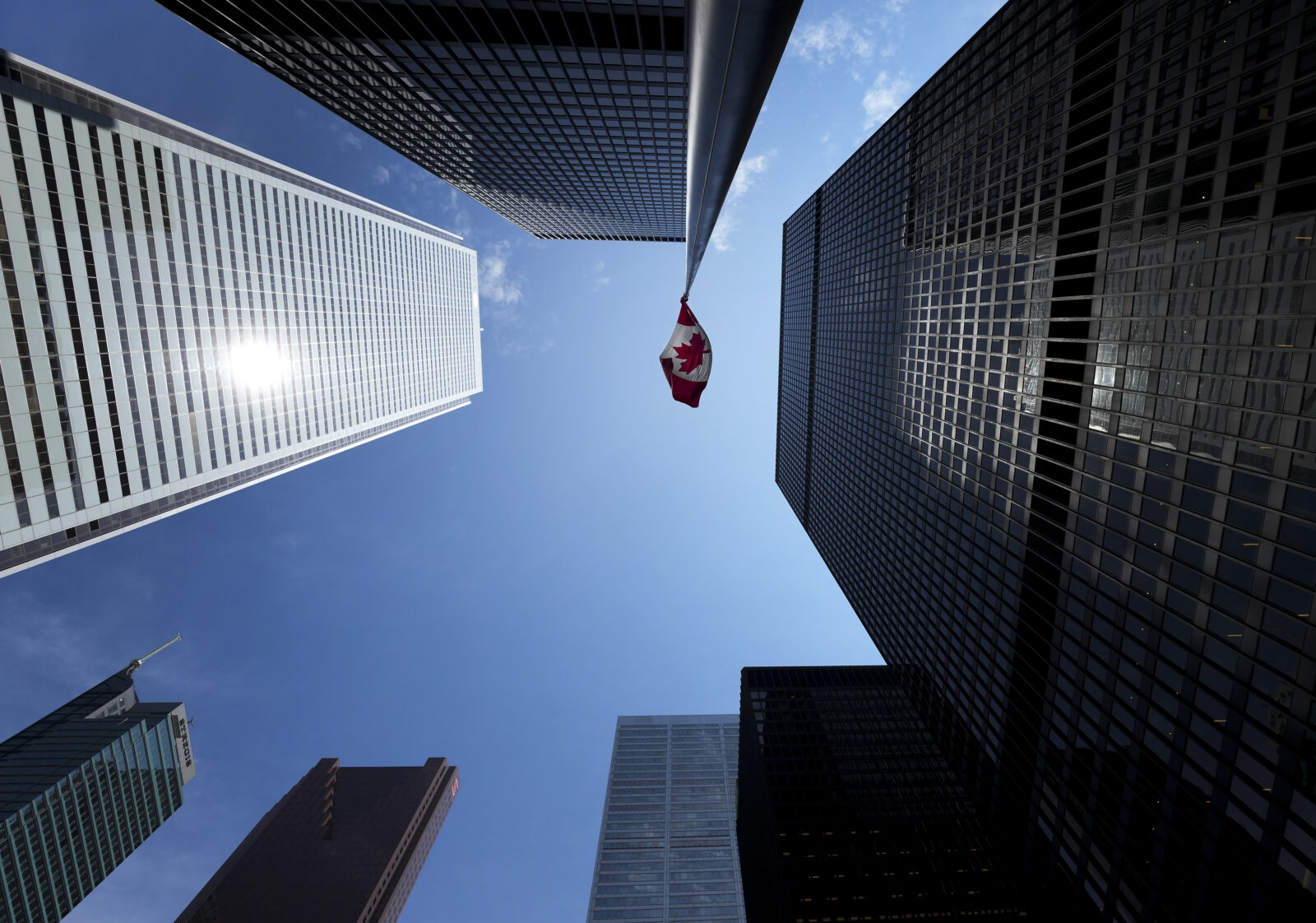 The Bay Street Financial District is shown with the Canadian flag in Toronto