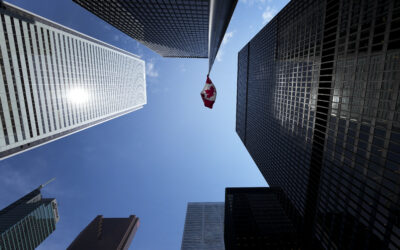 The Bay Street Financial District is shown with the Canadian flag in Toronto